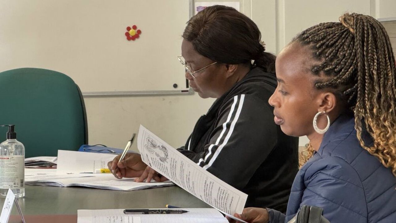 Deux femmes assises de profil sont en train de suivre un cours de français.